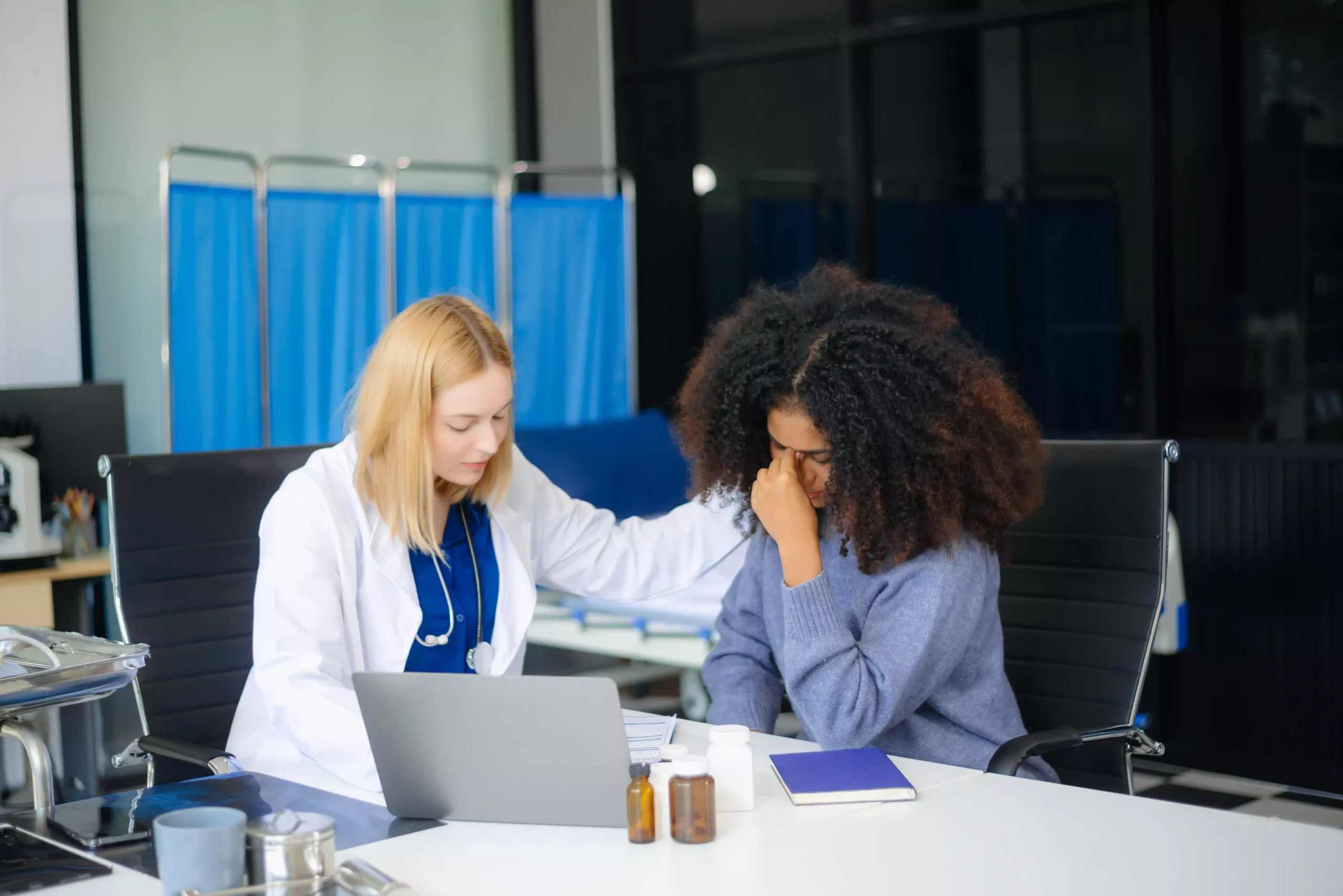Profissional recebendo apoio psicológico de uma médica em consultório.
