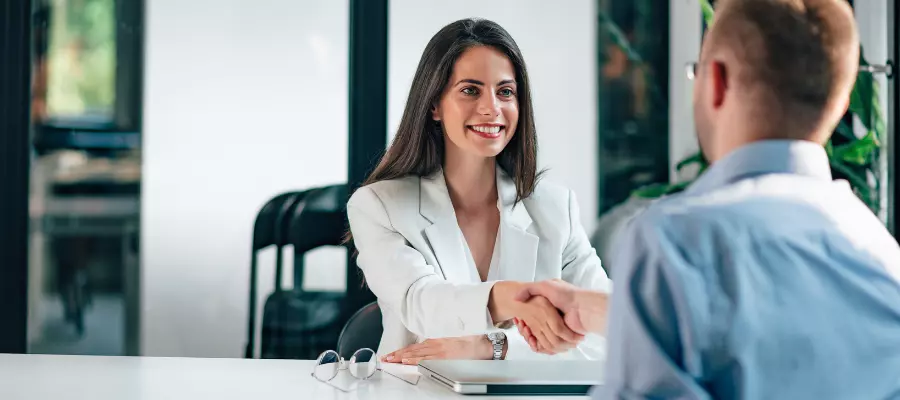 gerente de recursos humanos Gerente de RH cumprimentando um candidato, destacando a importância do contato pessoal na gestão de recursos humanos.