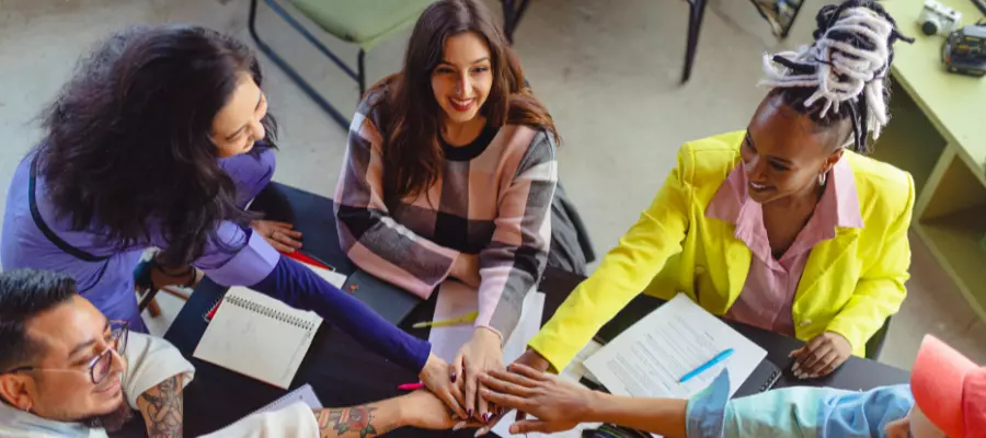 Cinco profissionais participando de uma sessão de networking, indicando colaboração e troca de ideias.